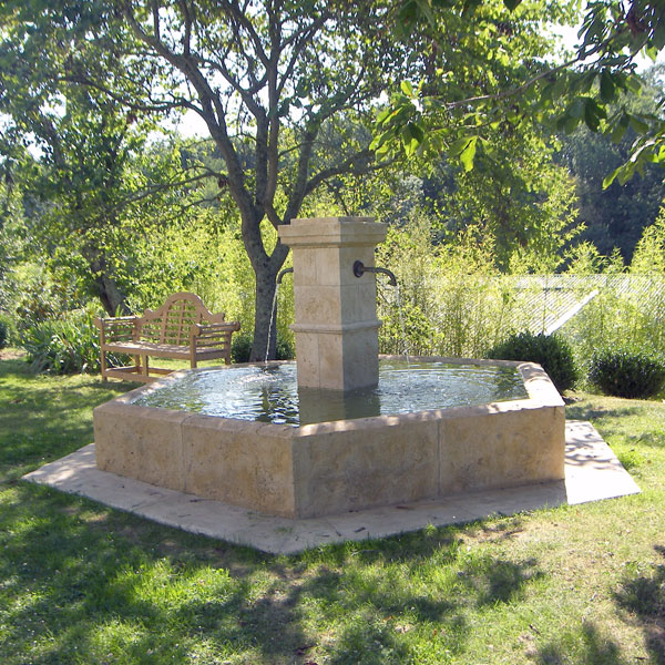fontaine hexagonale avec bassin et pilier central en pierre de taille style fontaine provençale