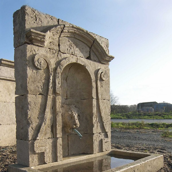 Fontaine en pierre avec fronton sculpté tête de lion et bassin rectangulaire