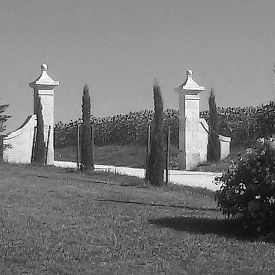 piliers d'entrée avec chapiteau orné d'une boule en pierre taillée dans la masse