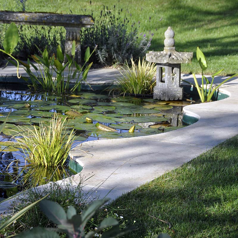 natural stone paving around a garden pond