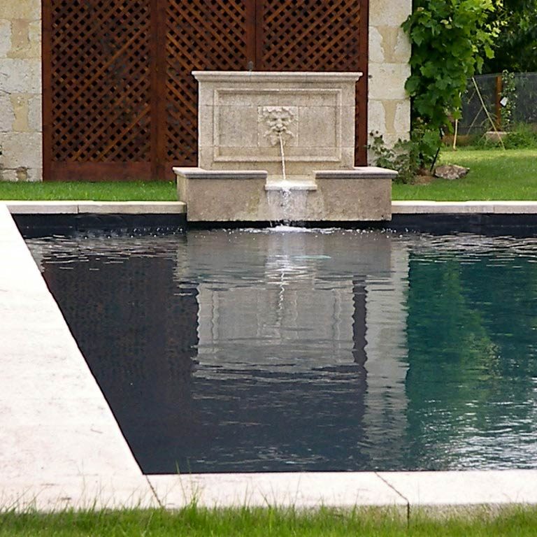 Piscine avec une fontaine intégrée en pierre de taille, ornée d'une tête de Bacchus sculptée