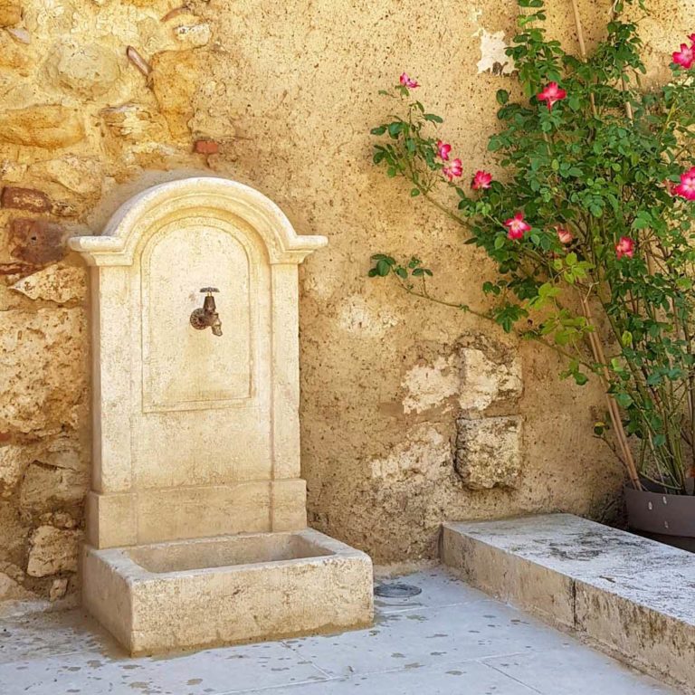fontaine murale adossée en pierre naturelle avec bassin simple et fronton mouluré