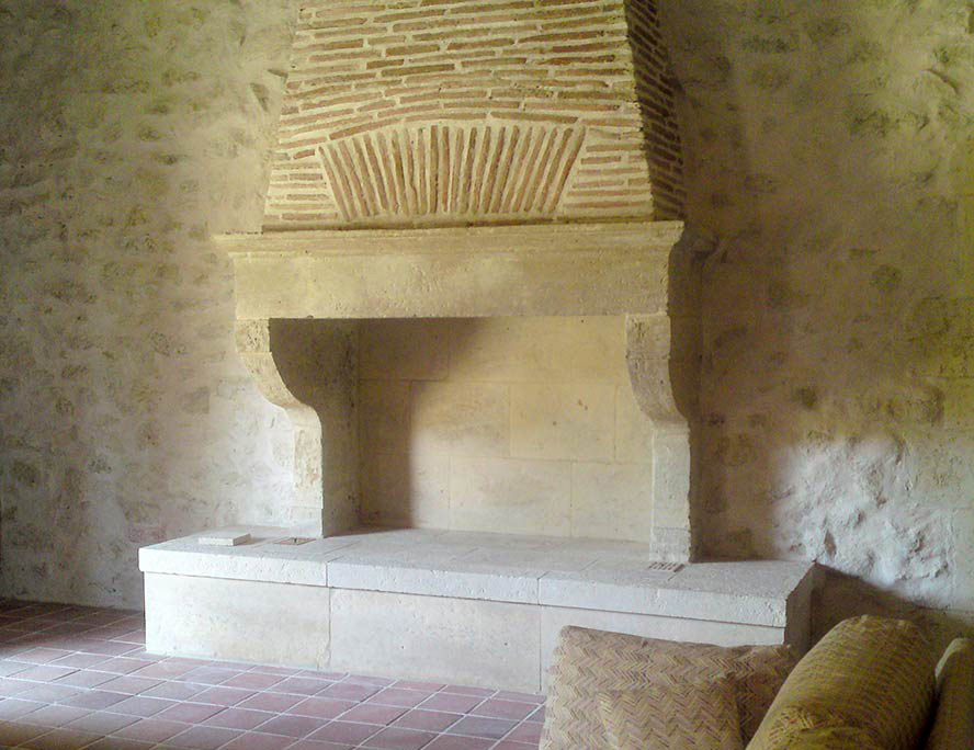 cheminée avec socle jambages et linteau en pierre naturelle manteau en briquettes arc de décharge