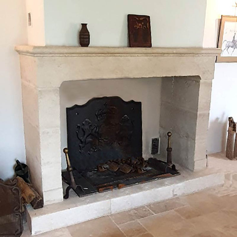 cheminée en pierre de taille réalisée et patinée sur mesure avec jambages simples et linteau à moulures
