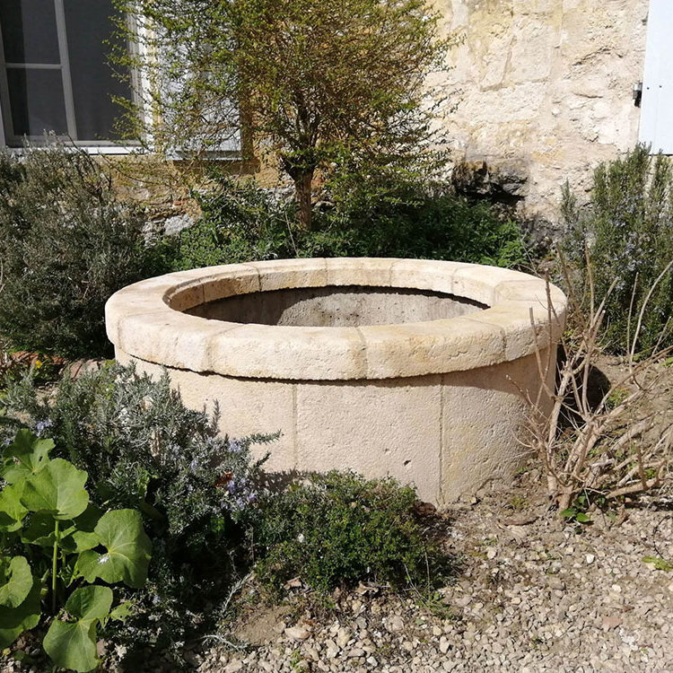 habillage d'un puits buse en béton avec un placage en pierre naturelle réalisé sur mesure margelle épaisse en pierre de taille