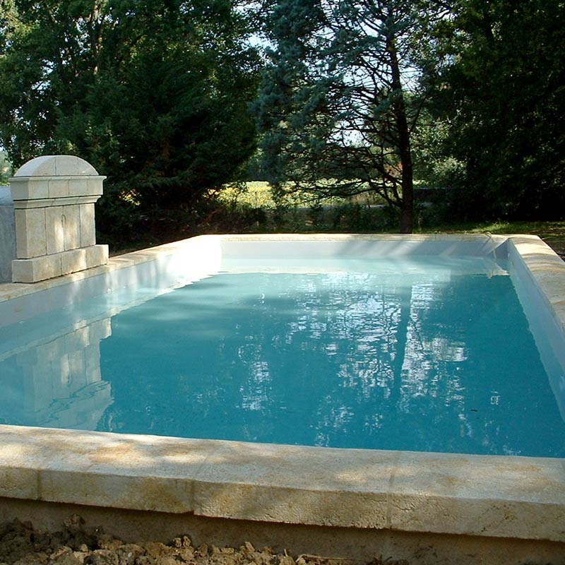 margelle de piscine et fronton en pierre de taille sur mesure avec patine style bassin ancien