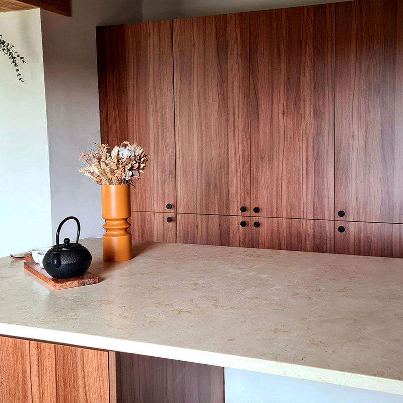 plan de travail en pierre calcaire naturelle beige réalisé sur mesure en îlot cuisine moderne contemporaine meubles en bois cuisiniste menuisier ébéniste